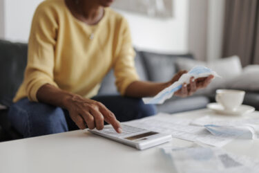 close-up-of-a-mid-adult-woman-checking-her-energy-bills-at-home-sitting-in-her-living-room-she-has-a-worried-expression